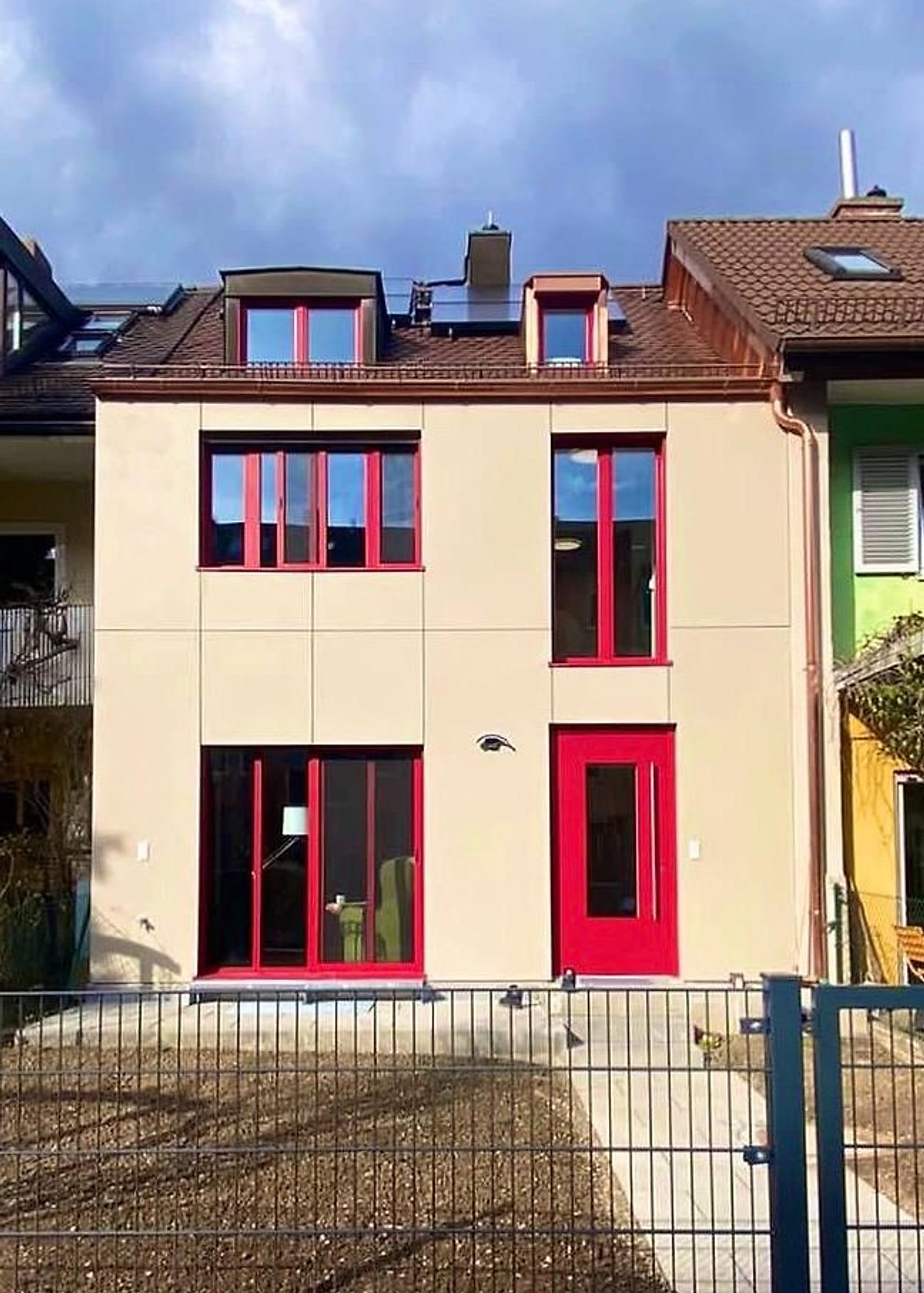 Gepflegte Hausfassade mit roten Fensterrahmen
